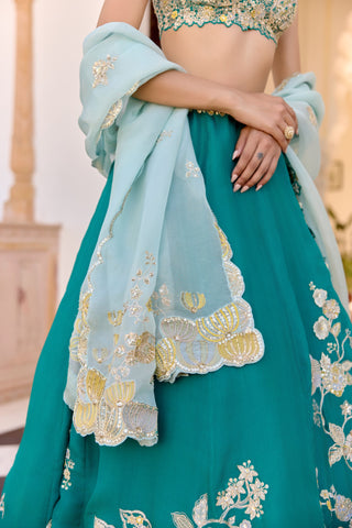 Close view of pale aqua dupatta with scalloped border and lotus motifs over the pine green skirt by Osaa by Adarsh at Mrs. G