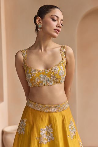 Waist-up view of marigold blouse with scalloped neckline, wide straps and silver flower motifs by Osaa by Adarsh at Mrs. G