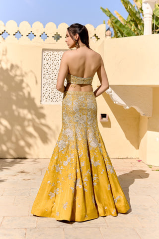 Back view of canary yellow fish cut lehenga with a bare-back halter top and silver flowers by Osaa by Adarsh at Mrs. G