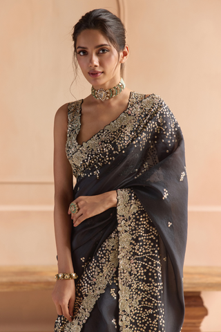 Waist-up view of black saree and V-neck blouse with gold flower and sequin embroidery by Osaa by Adarsh at Mrs. G