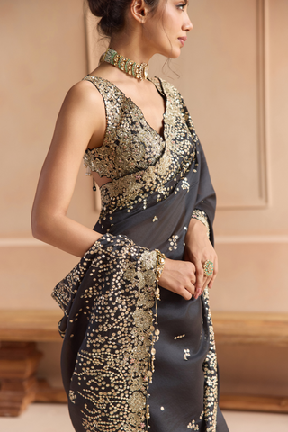 Close-up of black saree pallu with gold flower border, sequin clusters and beaded tassel edge by Osaa by Adarsh at Mrs. G