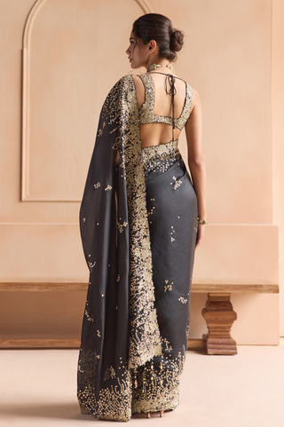 Back view of black saree with sequin pallu and cut-out back blouse with tie closure by Osaa by Adarsh at Mrs. G