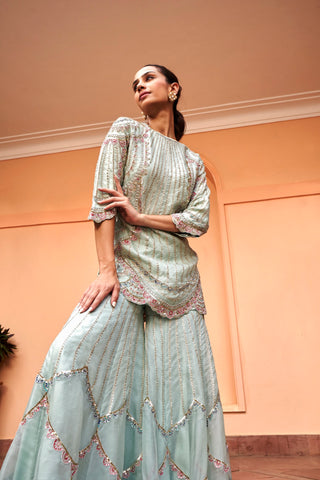 Low-angle side view of pastel blue kurta with scalloped hem and chevron embroidered sharara by Osaa by Adarsh at Mrs. G