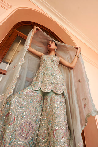 Low-angle view of cadet blue embroidered kurta with organza dupatta lifted overhead by Osaa by Adarsh at Mrs. G