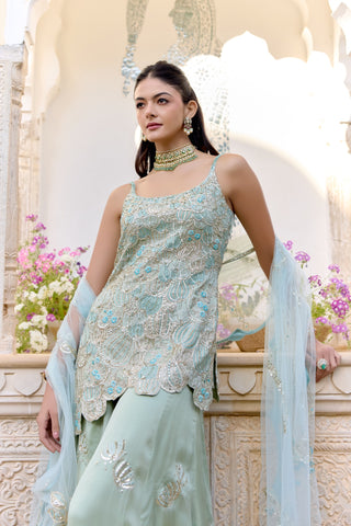 Three-quarter view of sage kurta with scalloped hem and shell-motif sharara by Osaa by Adarsh at Mrs. G