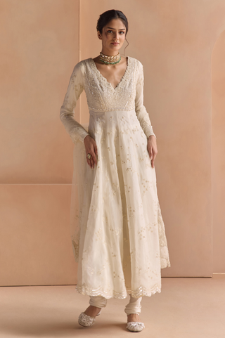 Front view of ivory anarkali with scalloped V-neck bodice, full sleeves, churidar and tulle dupatta by Osaa by Adarsh at Mrs. G