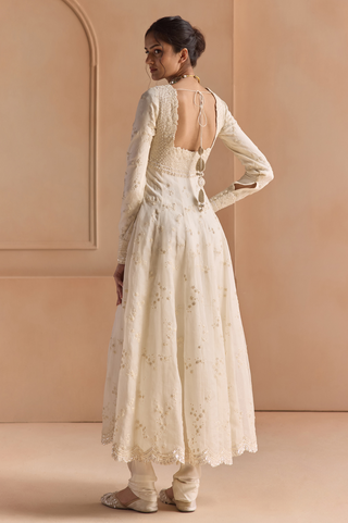 Back view of ivory anarkali with open back and tie closure over a flared embroidered skirt by Osaa by Adarsh at Mrs. G