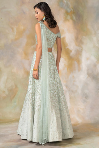Light green one shouldered draped blouse and lehenga set