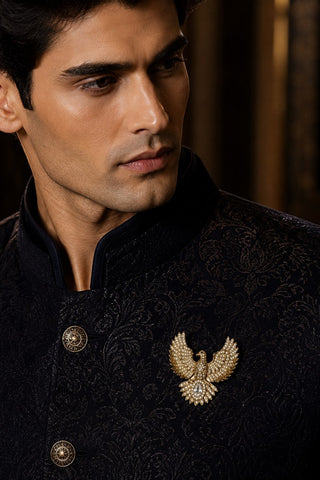 On-model view of the gold zircon bird brooch by Vivinia by Vidhi Mehra worn with a black sherwani at Mrs. G