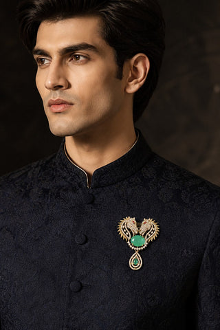 On-model view of the gold and forest green zircon horse brooch by Vivinia by Vidhi Mehra worn with a black sherwani at Mrs. G