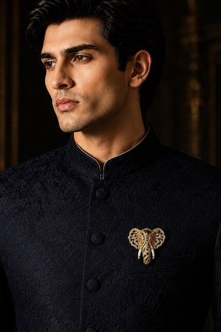On-model view of the gold zircon elephant brooch with ivory-tone tusks by Vivinia by Vidhi Mehra worn with a black sherwani at Mrs. G