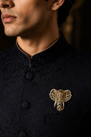 Close-up on model of the gold zircon elephant brooch with ivory-tone tusks showing openwork ears and detailed trunk at Mrs. G