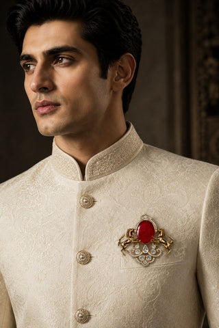 On-model view of the gold and ruby red horse brooch with red stone by Vivinia by Vidhi Mehra worn with a cream sherwani at Mrs. G