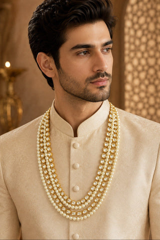On-model view of the white multi-layer pearl kundan mala by Vivinia by Vidhi Mehra worn with a cream sherwani at Mrs. G