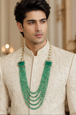 On-model view of the jade green layered beaded kundan groom mala by Vivinia by Vidhi Mehra worn with a ivory embroidered sherwani at Mrs. G