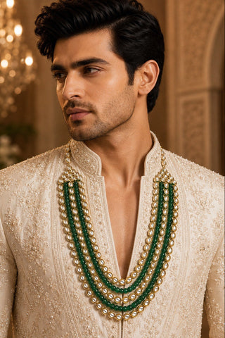 On-model view of the emerald green beaded kundan layered mala by Vivinia by Vidhi Mehra worn with a cream sherwani at Mrs. G
