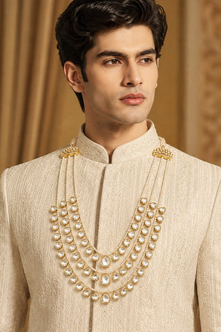 On-model view of the white three-layer pearl kundan groom mala by Vivinia by Vidhi Mehra worn with a cream sherwani at Mrs. G