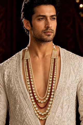 On-model view of the white and ruby red layered kundan pearl mala by Vivinia by Vidhi Mehra worn with a ivory open-front sherwani at Mrs. G