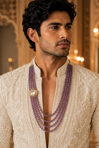 On-model view of the amethyst purple four-layer beaded kundan groom mala by Vivinia by Vidhi Mehra worn with a cream embroidered sherwani at Mrs. G