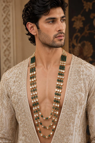 On-model view of the emerald green three-layer beaded kundan long mala by Vivinia by Vidhi Mehra worn with a beige embroidered open sherwani at Mrs. G