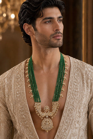 On-model view of the emerald green beaded kundan pendant groom necklace by Vivinia by Vidhi Mehra worn with a beige embroidered kurta at Mrs. G