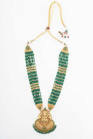 Flat product view of the emerald green beaded temple pendant necklace showing gold-plated temple pendant with deity motifs at Mrs. G