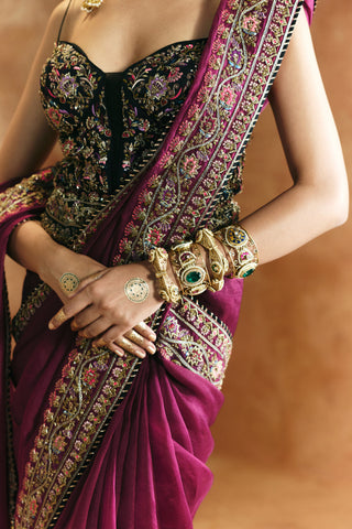 Close-up of the black corset blouse's floral embroidery and the zardozi vine border of the magenta saree by Aman Takyar at Mrs. G