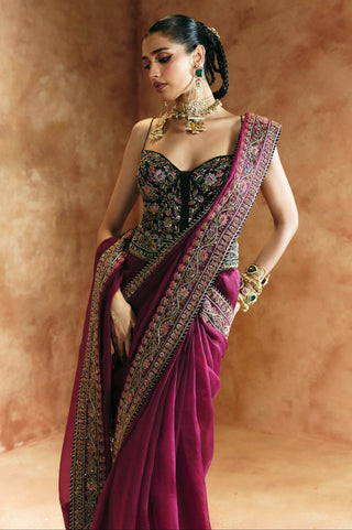 Three-quarter view of the black corset saree set with the head turned and the pallu over the arm by Aman Takyar at Mrs. G