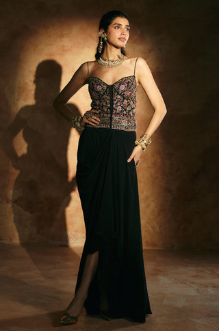 Three-quarter view of the black corset set showing the side slit of the floor-length draped skirt by Aman Takyar at Mrs. G
