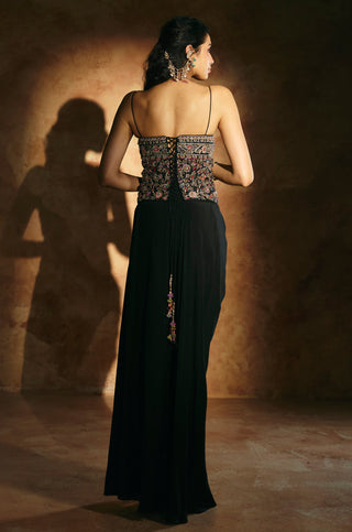 Back view of the black corset set with lace-up corset and a tassel hanging from the skirt by Aman Takyar at Mrs. G
