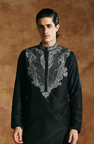 Full-length view of the black kurta set with the paisley-shaped silver yoke and arms relaxed by Aman Takyar at Mrs. G