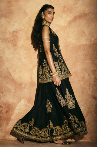 Side view of the black sharara flared hem with its deep gold embroidered border by Aman Takyar at Mrs. G