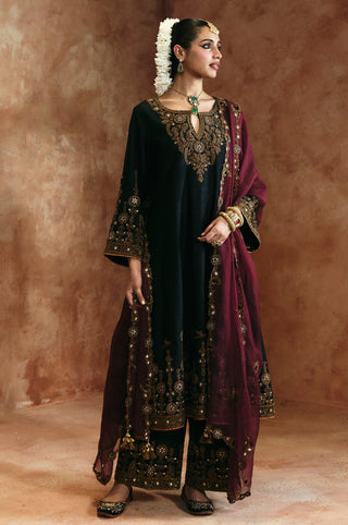 Full-length three-quarter view of the black keyhole kurta set with the dupatta over one shoulder by Aman Takyar at Mrs. G