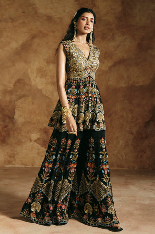 Three-quarter view of the black sharara set with floral vines and geometric gold border by Aman Takyar at Mrs. G