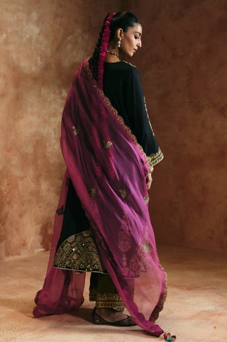 Side back view of the black v-neck kurta set with the pink dupatta flowing behind by Aman Takyar at Mrs. G