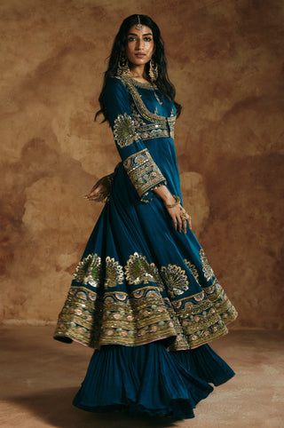 Side view of the teal blue anarkali in motion, with the wide peacock hem band by Aman Takyar at Mrs. G