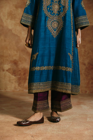 Close-up of the teal blue kurta's teardrop medallion, hem band and plum pants' embroidered cuffs by Aman Takyar at Mrs. G