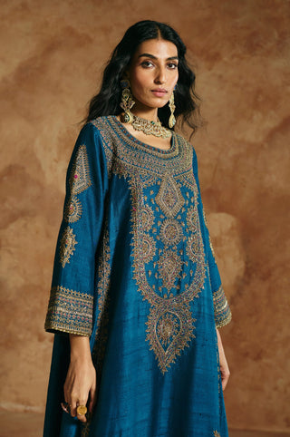Waist-up close-up of the teal blue kurta's antique-gold neckline and medallion embroidery by Aman Takyar at Mrs. G