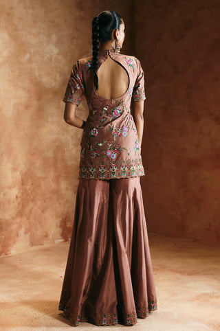 Back view of the bronze sharara set with the round cut-out back and wide-flared sharara by Aman Takyar at Mrs. G