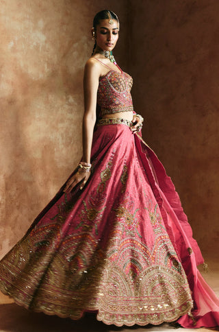 Side-turned view of the carrot pink lehenga flaring with the sheer dupatta trailing behind by Aman Takyar at Mrs. G