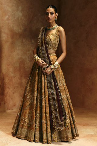 Full-length view of the copper gold lehenga set with the wine dupatta falling down the side by Aman Takyar at Mrs. G