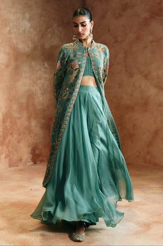 Walking view of the coral blue jacket worn open over the bandeau blouse and floating skirt by Aman Takyar at Mrs. G