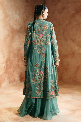 Back view of the coral blue jacket with large leaf embroidery over the flared skirt by Aman Takyar at Mrs. G
