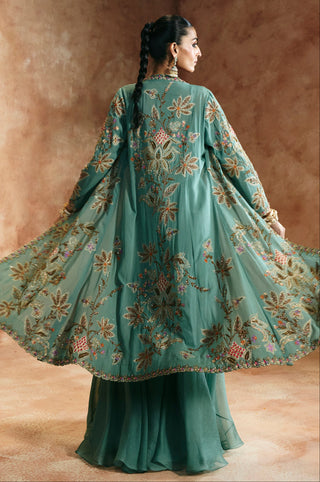 Back view of the coral blue jacket flaring open to show the scalloped edge and sheer skirt by Aman Takyar at Mrs. G