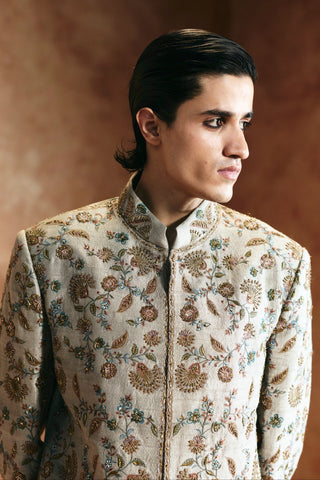 Close-up of the dull green sherwani's stand collar and floral embroidery across the shoulders by Aman Takyar at Mrs. G