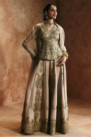 Three-quarter view of the gold flared sharara with embroidered panels and hem band by Aman Takyar at Mrs. G