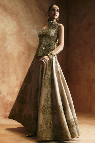 Full-length view of the sleeveless gold peplum top and wide-flared sharara by Aman Takyar at Mrs. G