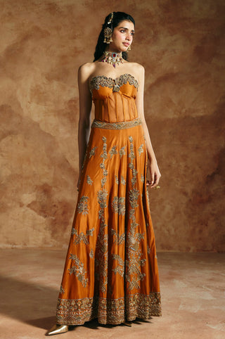 Full-length view of the orange corset and sharara set, head turned, showing the leaf sprays on the flare by Aman Takyar at Mrs. G