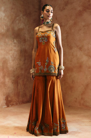 Full-length front view of the orange sharara set with the scalloped embroidered sharara hem by Aman Takyar at Mrs. G