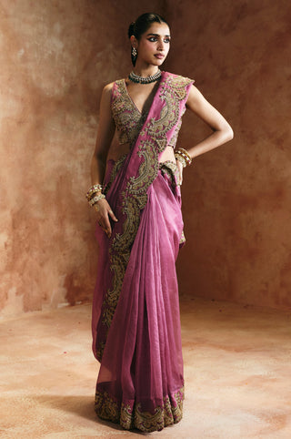 Full-length view of the peach saree set with one hand on hip and the gold border over the shoulder by Aman Takyar at Mrs. G